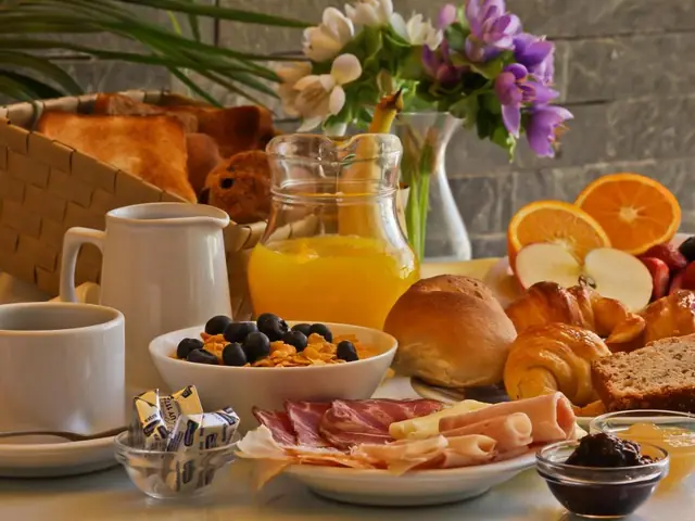 Desayuno buffet con frutas, fiambres y medialunas en el De la Plaza Hotel