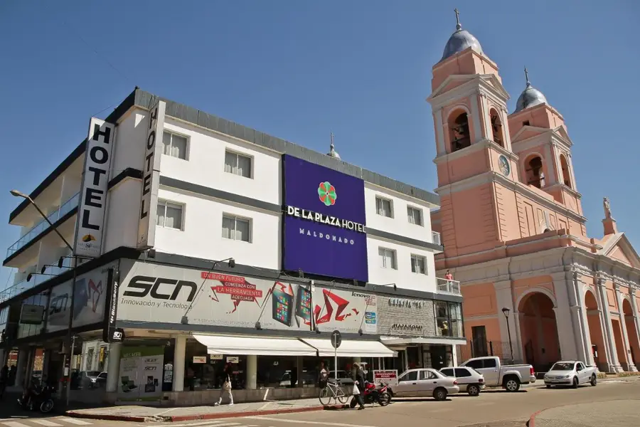Fachada del De la Plaza Hotel con su cartel, al lado de la Catedral San Fernando de Maldonado